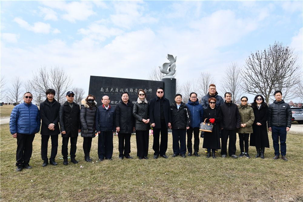 A group of people posing for a photo in front of a statue

Description automatically generated