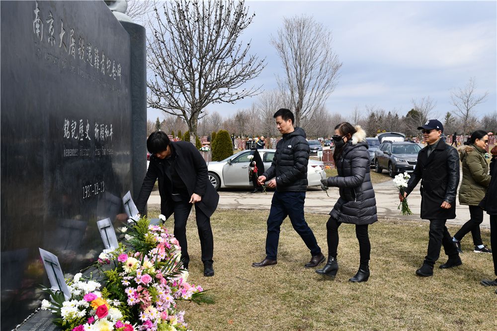 A group of people standing around a grave

Description automatically generated with low confidence