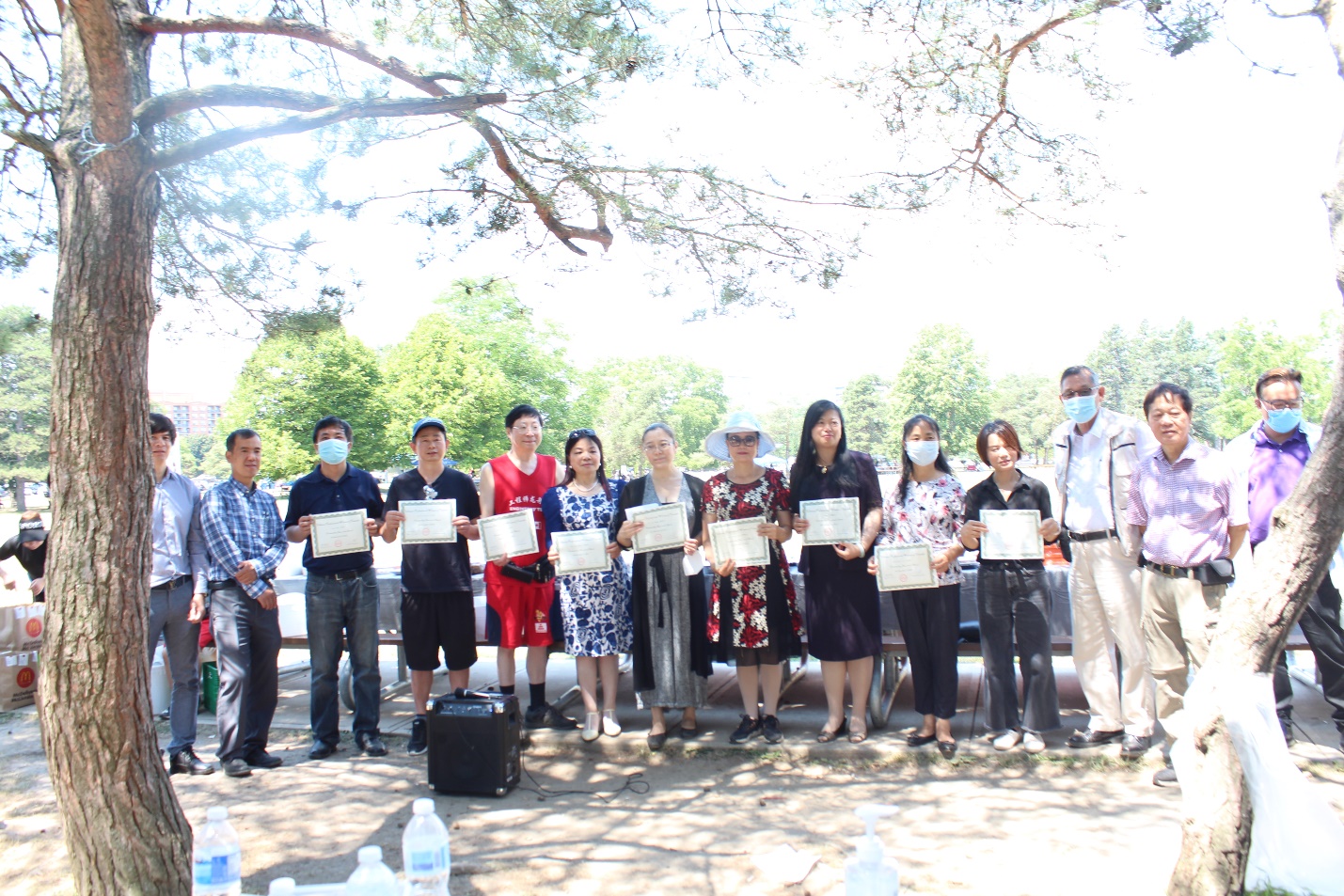 A group of people standing under a tree Description automatically generated with medium confidence