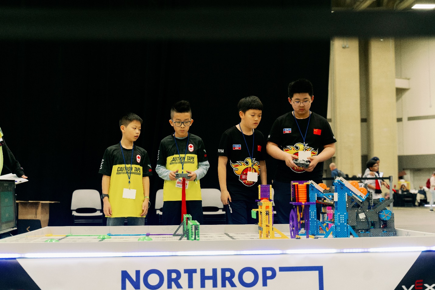 A group of boys standing next to a table with toys Description automatically generated with low confidence