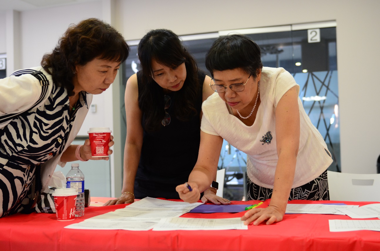 A group of women looking at papers Description automatically generated