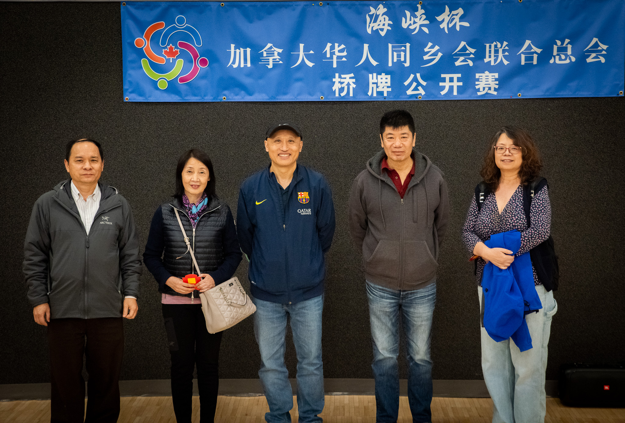 A group of people standing in front of a banner

Description automatically generated