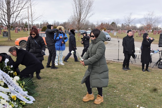 A group of people standing in a field

Description automatically generated