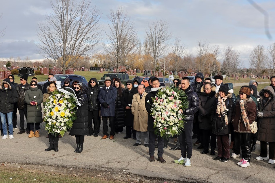 A group of people standing together holding flowers

Description automatically generated