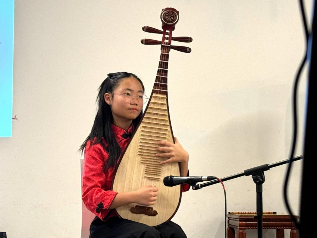 A child playing a stringed instrument

Description automatically generated