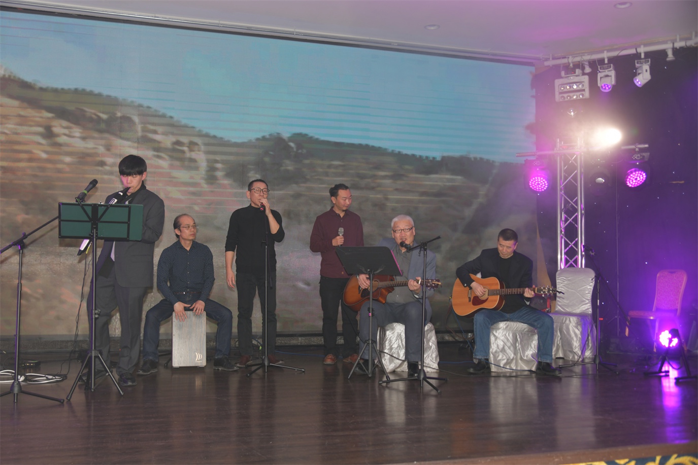 A group of men playing instruments on a stage

Description automatically generated