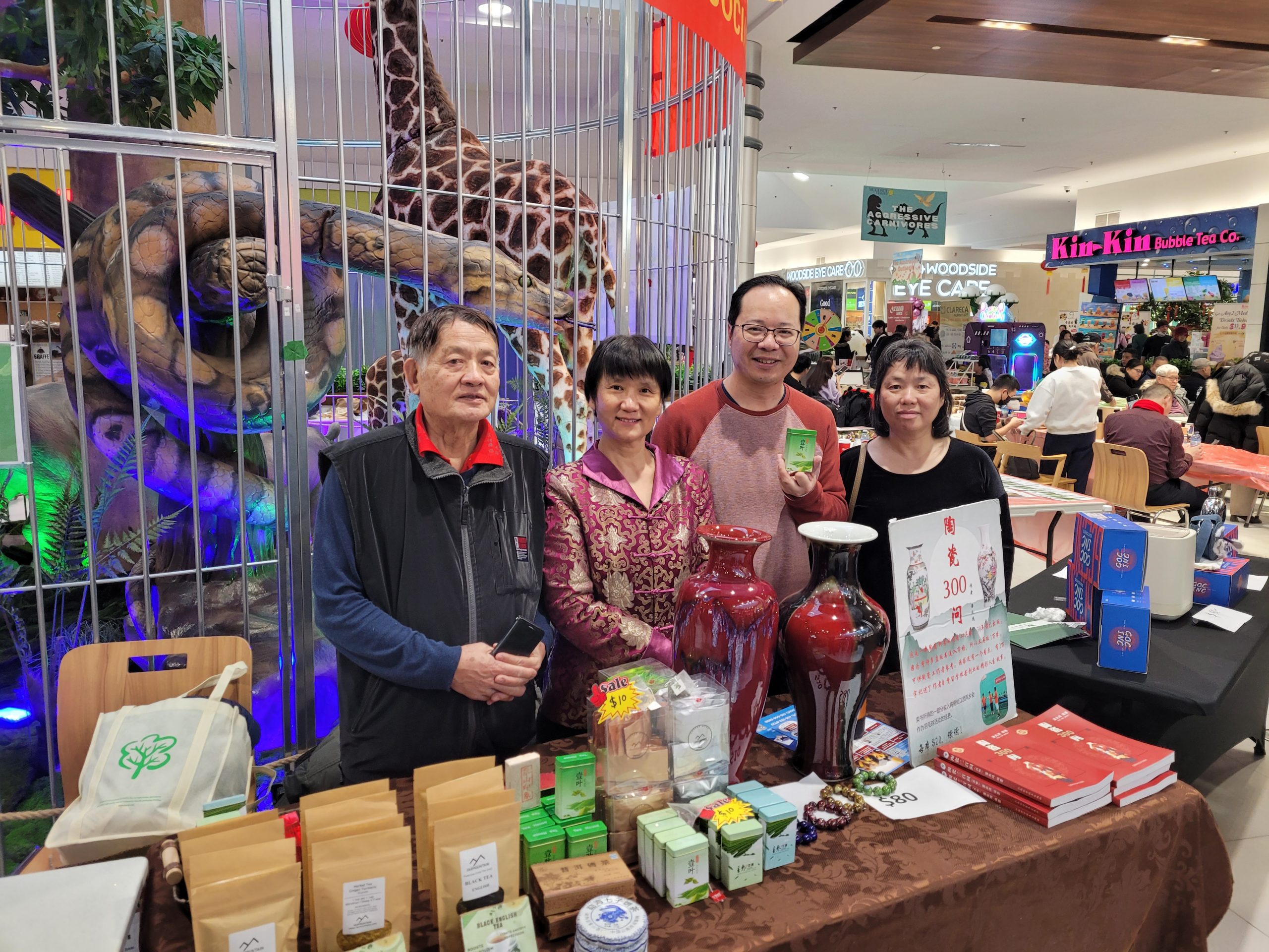 A group of people standing in front of a table

Description automatically generated