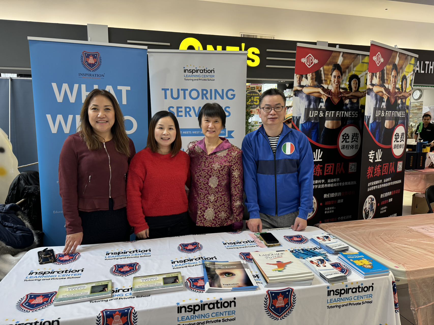 A group of people standing in front of a table

Description automatically generated