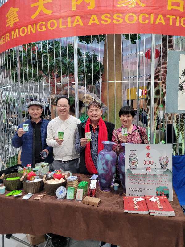 A group of people standing next to a table with objects on it

Description automatically generated