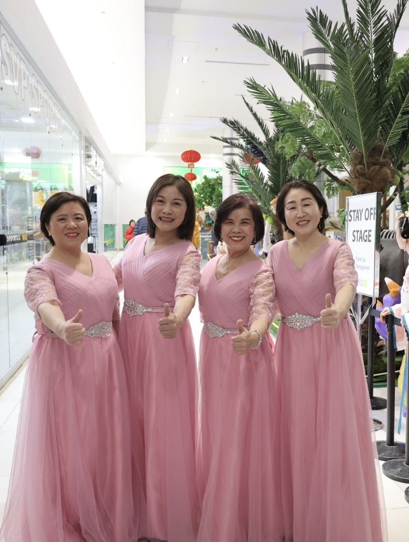 A group of women in pink dresses

Description automatically generated