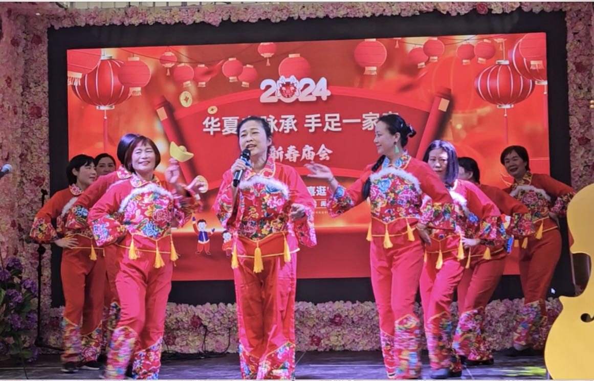 A group of women performing on a stage

Description automatically generated