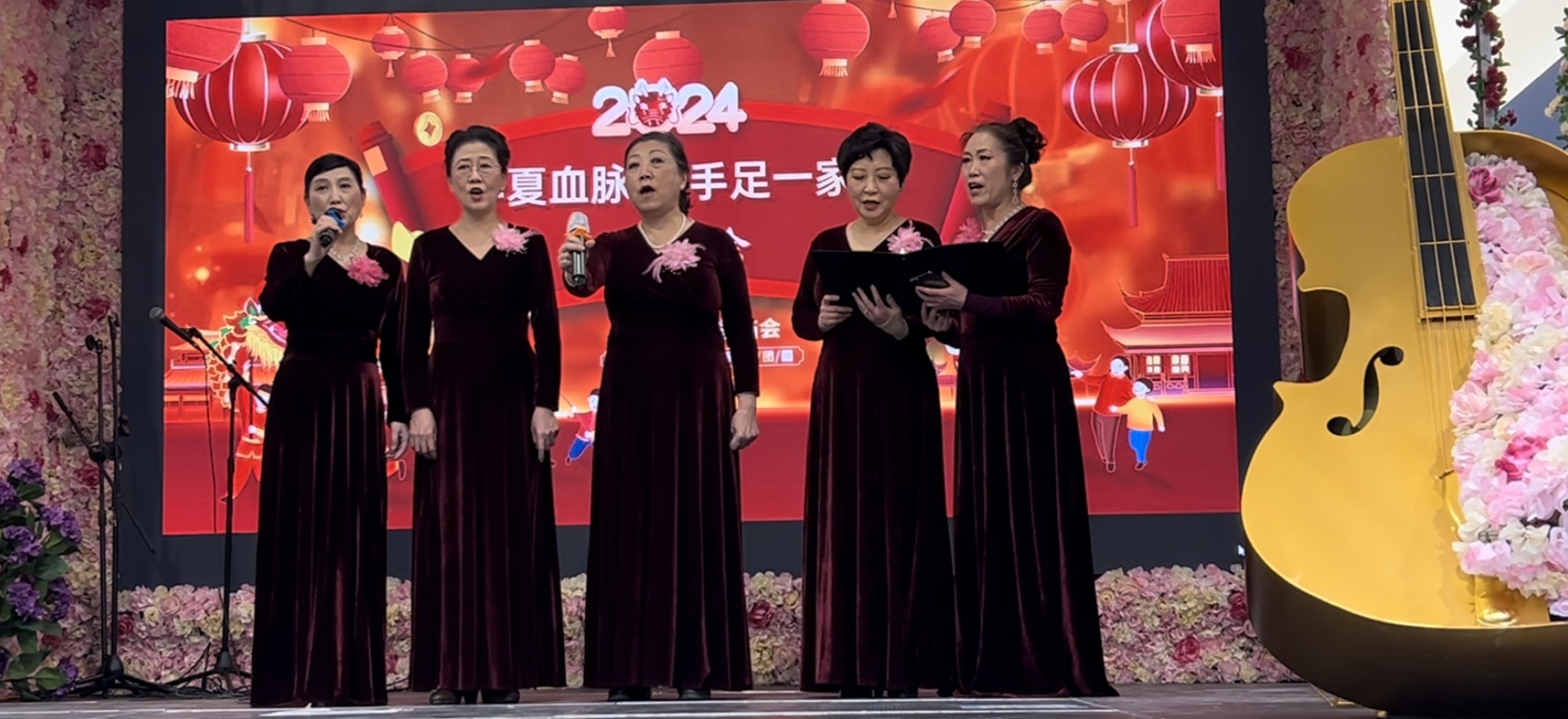 A group of women singing on stage

Description automatically generated