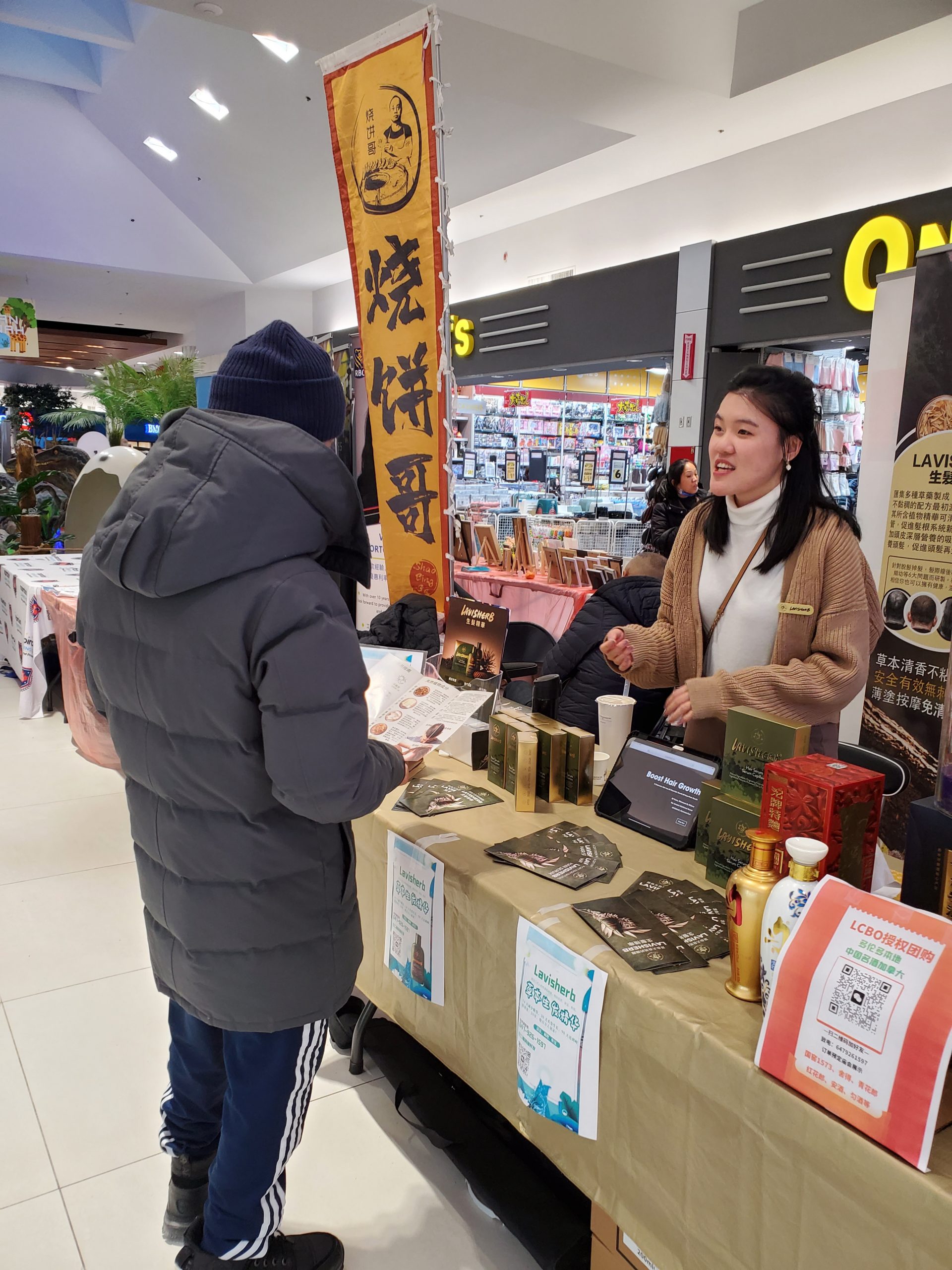 A person and person standing in front of a table

Description automatically generated