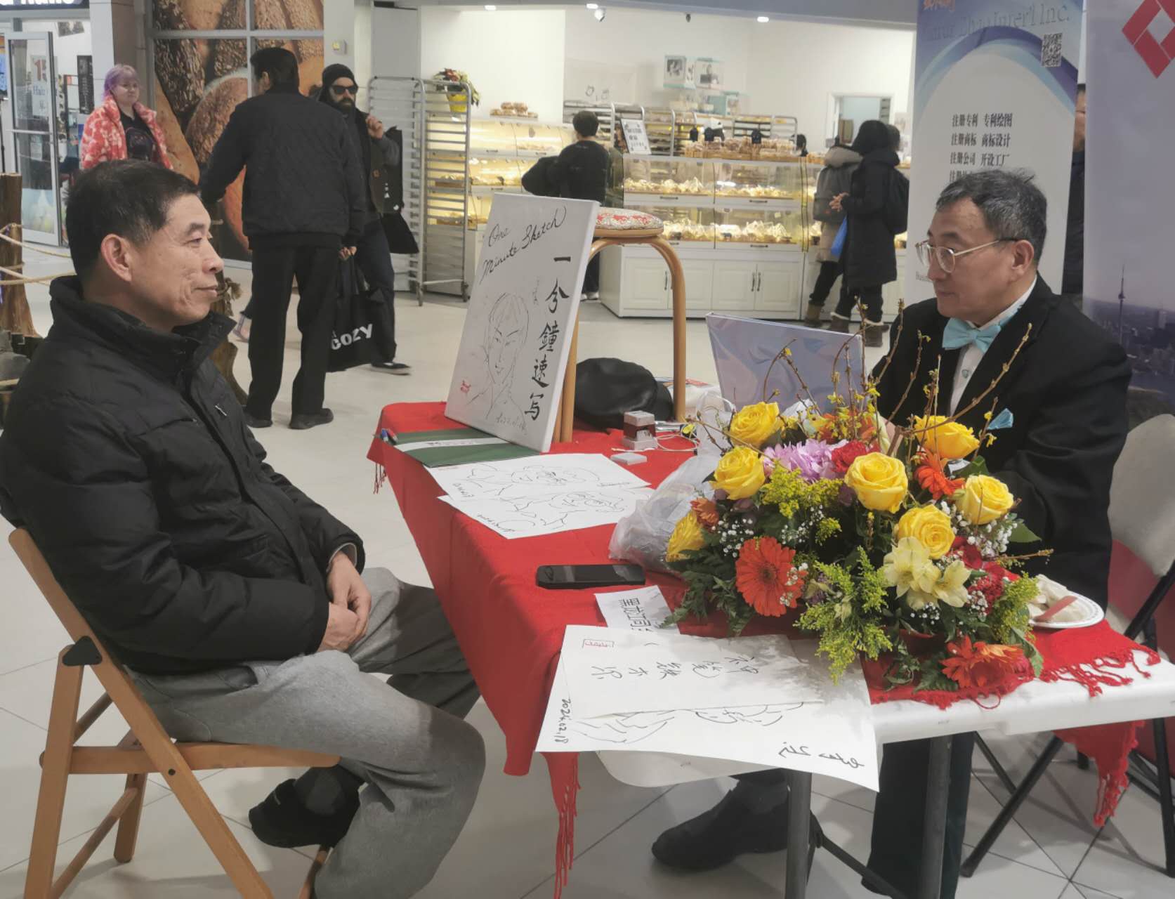 A person sitting at a table with flowers

Description automatically generated