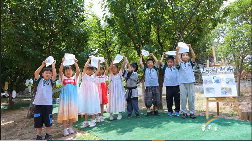 A group of children holding up paper Description automatically generated