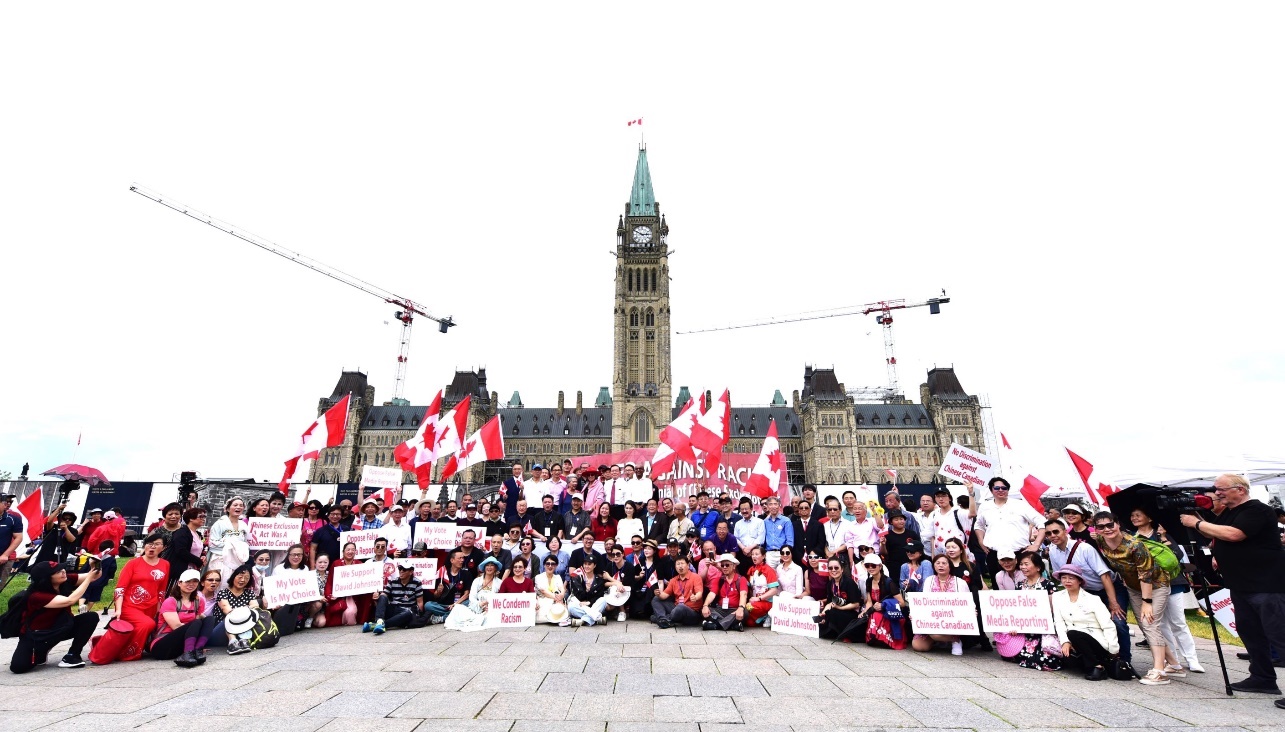 A group of people holding signs Description automatically generated