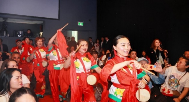 A group of women in red dresses dancing Description automatically generated