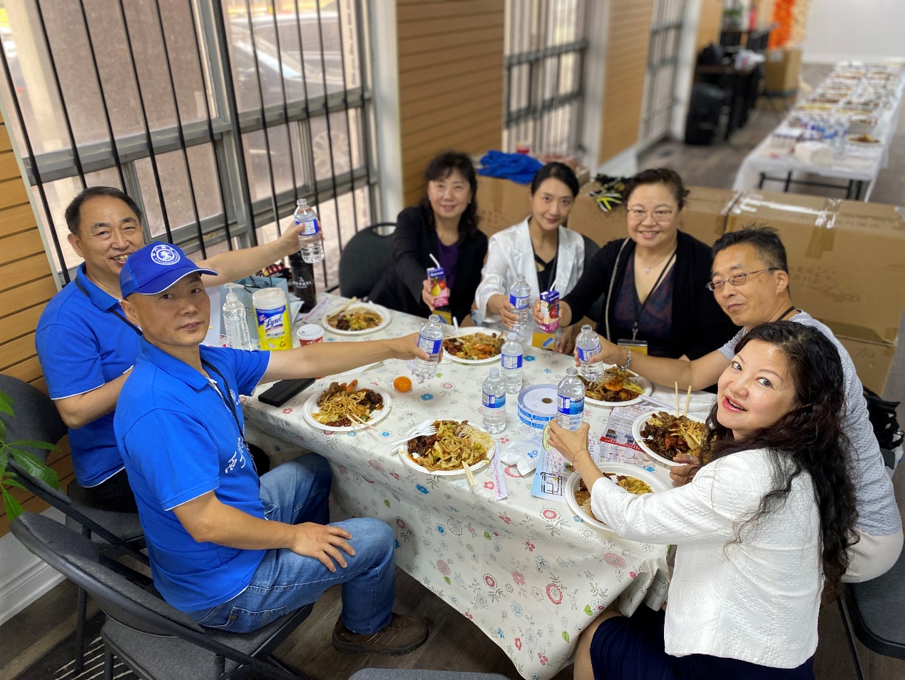 A group of people sitting around a table with food

Description automatically generated