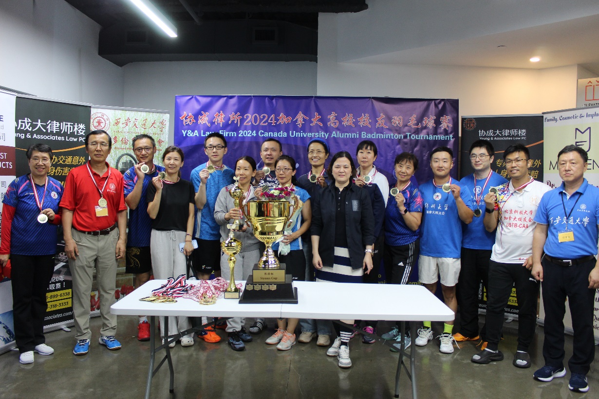 A group of people standing in front of a table with a trophy

Description automatically generated