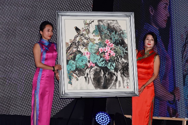 A group of women holding a painting Description automatically generated