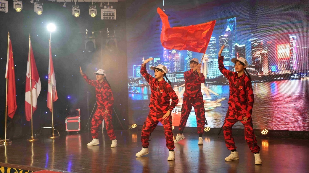 A group of people in red and black outfits on a stage Description automatically generated