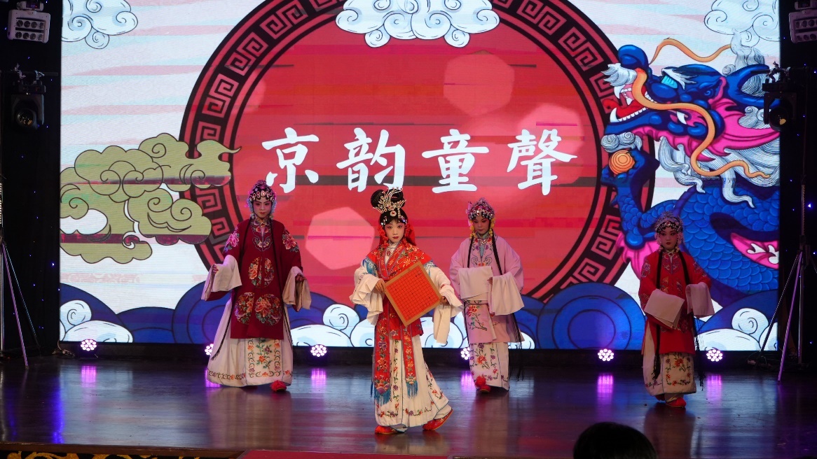 A group of people in traditional clothing on a stage Description automatically generated