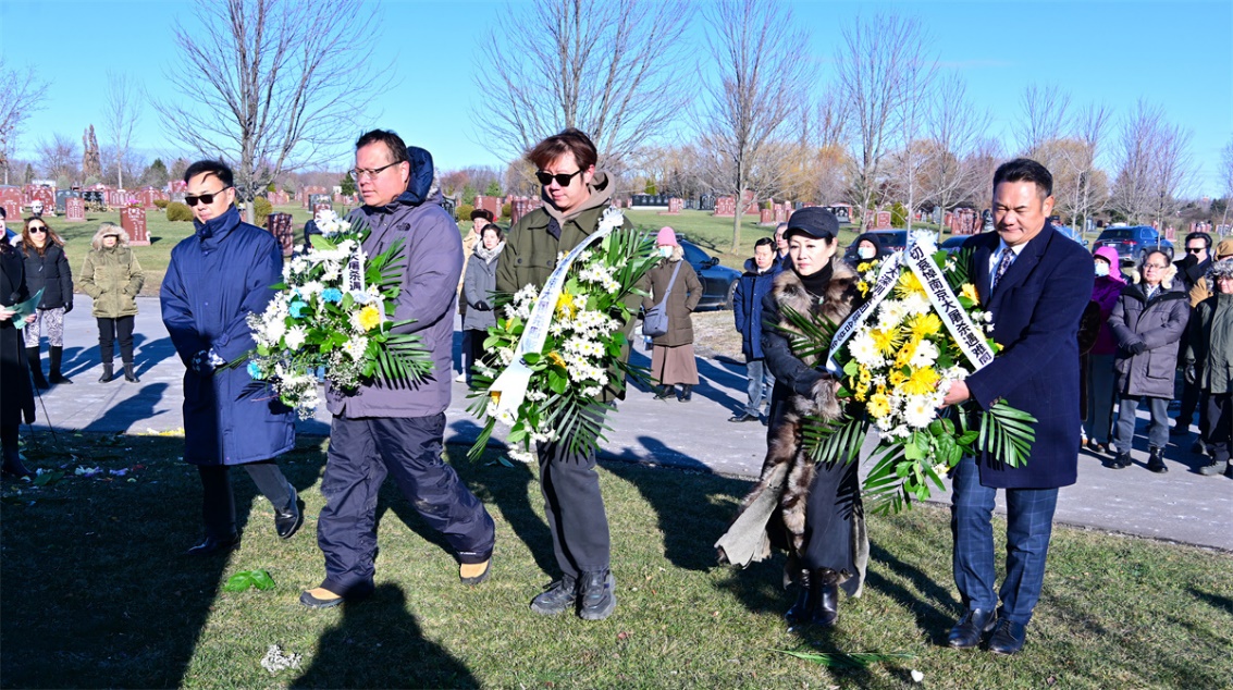 A group of people carrying flowers Description automatically generated