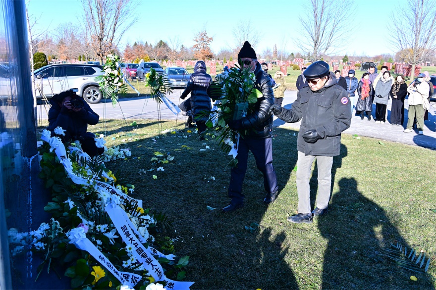 A group of people standing in a cemetery Description automatically generated