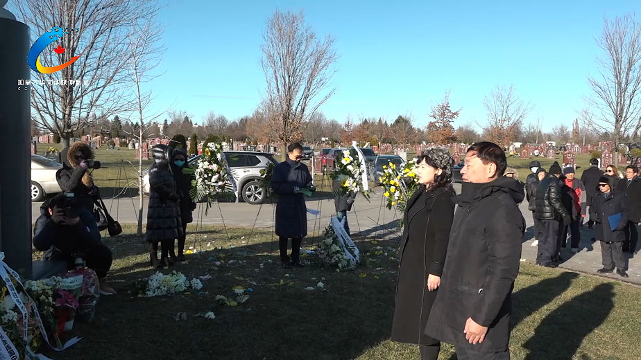 A group of people standing in a cemetery Description automatically generated