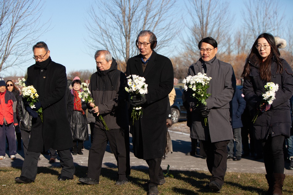 A group of people walking with flowers Description automatically generated