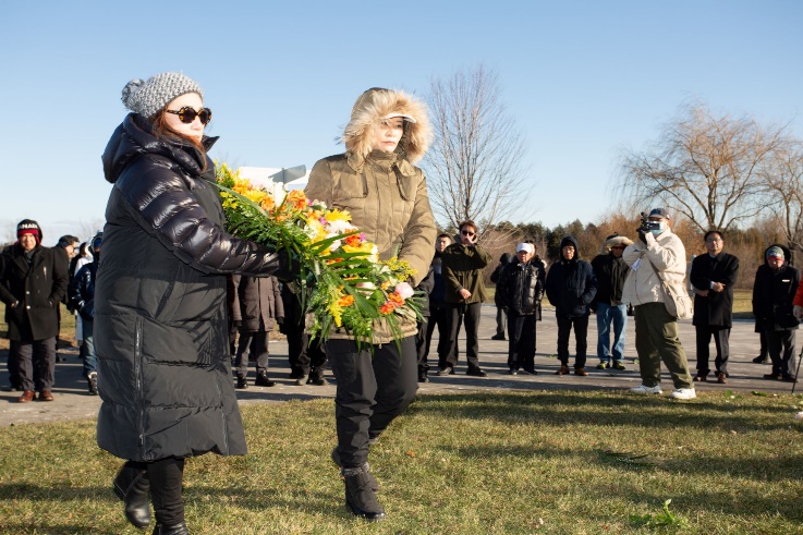 A group of people walking with flowers Description automatically generated