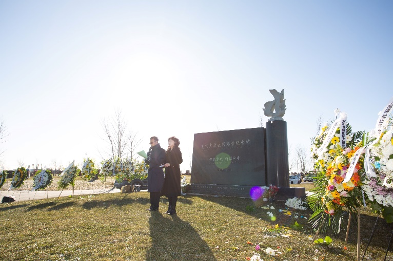 A person and person standing in front of a sign Description automatically generated