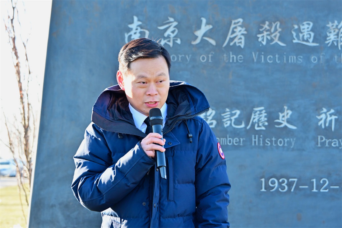 A person in a blue coat holding a microphone Description automatically generated