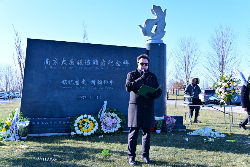 A person standing in front of a grave Description automatically generated