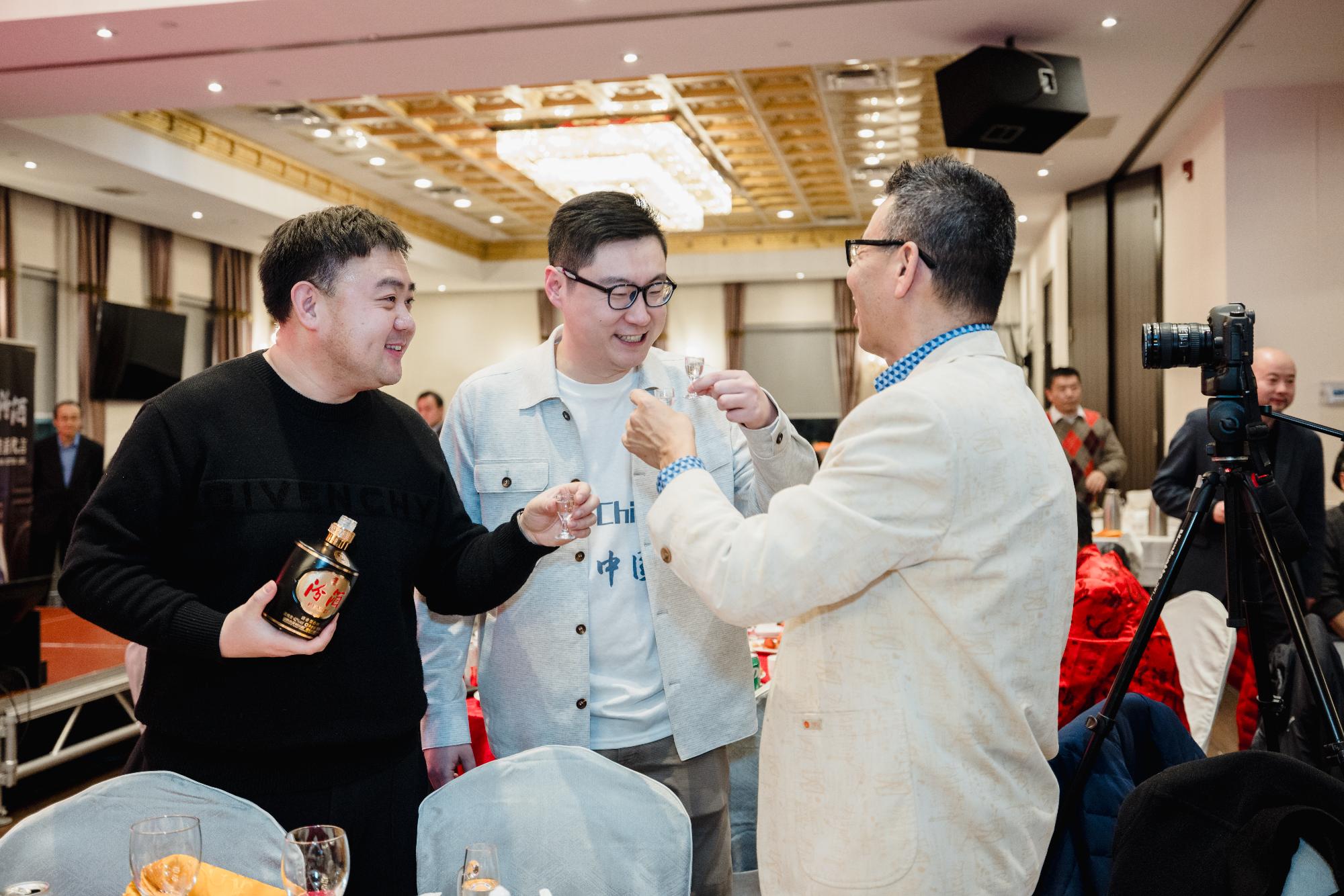 A group of men standing together and holding bottles of alcohol

Description automatically generated