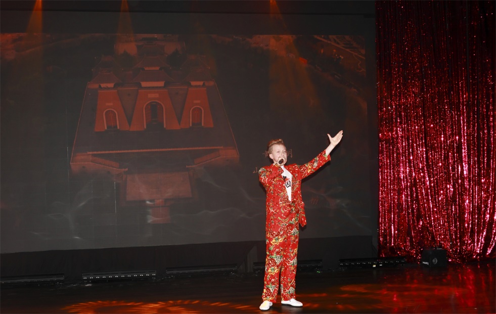 A person in a red suit on stage AI-generated content may be incorrect.